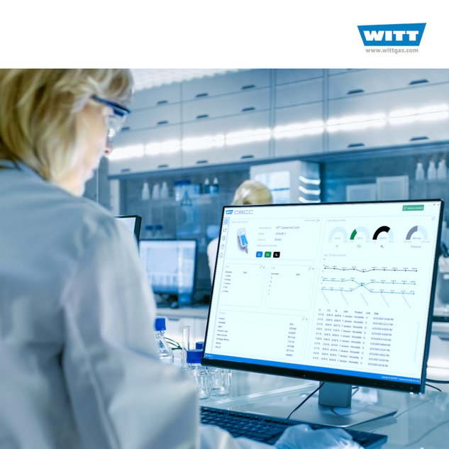 Female Scientist Working on her Computers (Mock-up Green Screen) In Modern Laboratory. Various Shelves with Beakers, Chemicals and Different Technical Equipment is Visible.